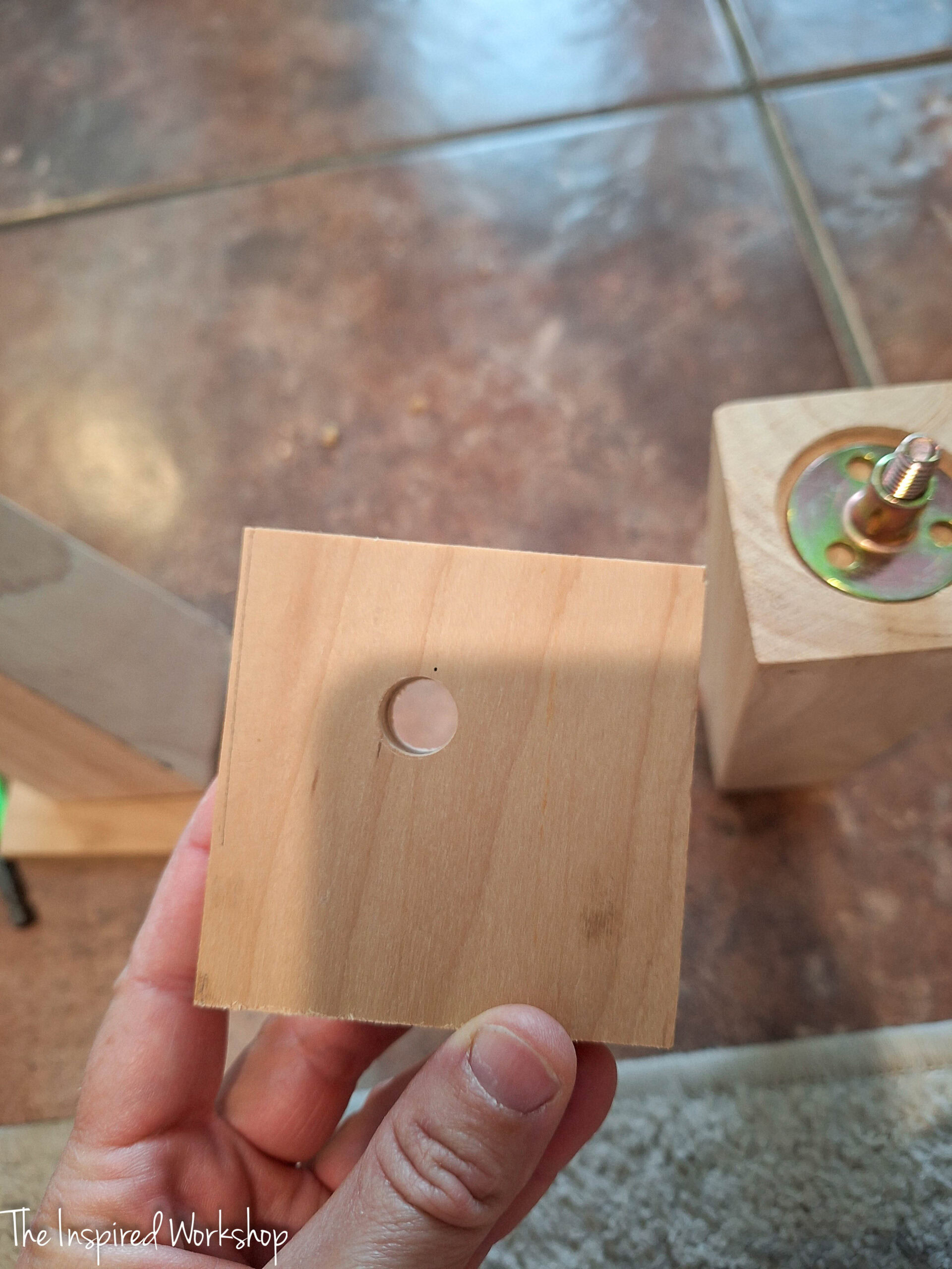 hole drilled in a square of plywood