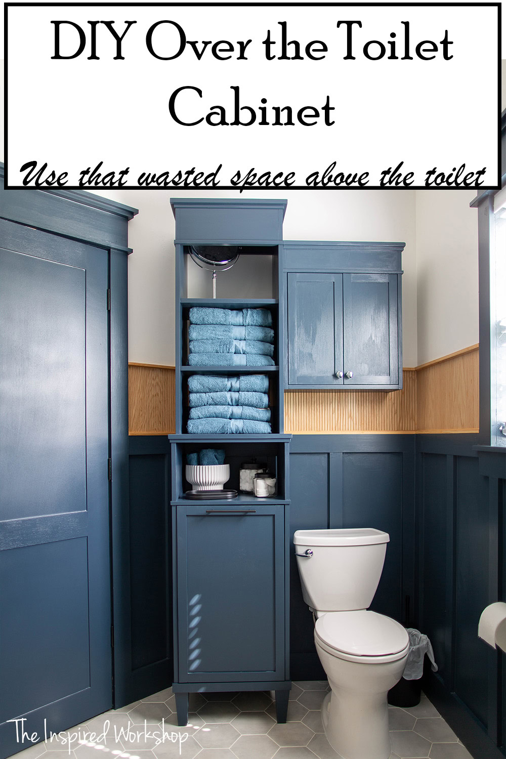 Picture of the bathroom wall with a linen cabinet and toilet and over the toilet cabinet. The two cabinets are both painted navy blue matching the board and batten on the lower portion of the walls