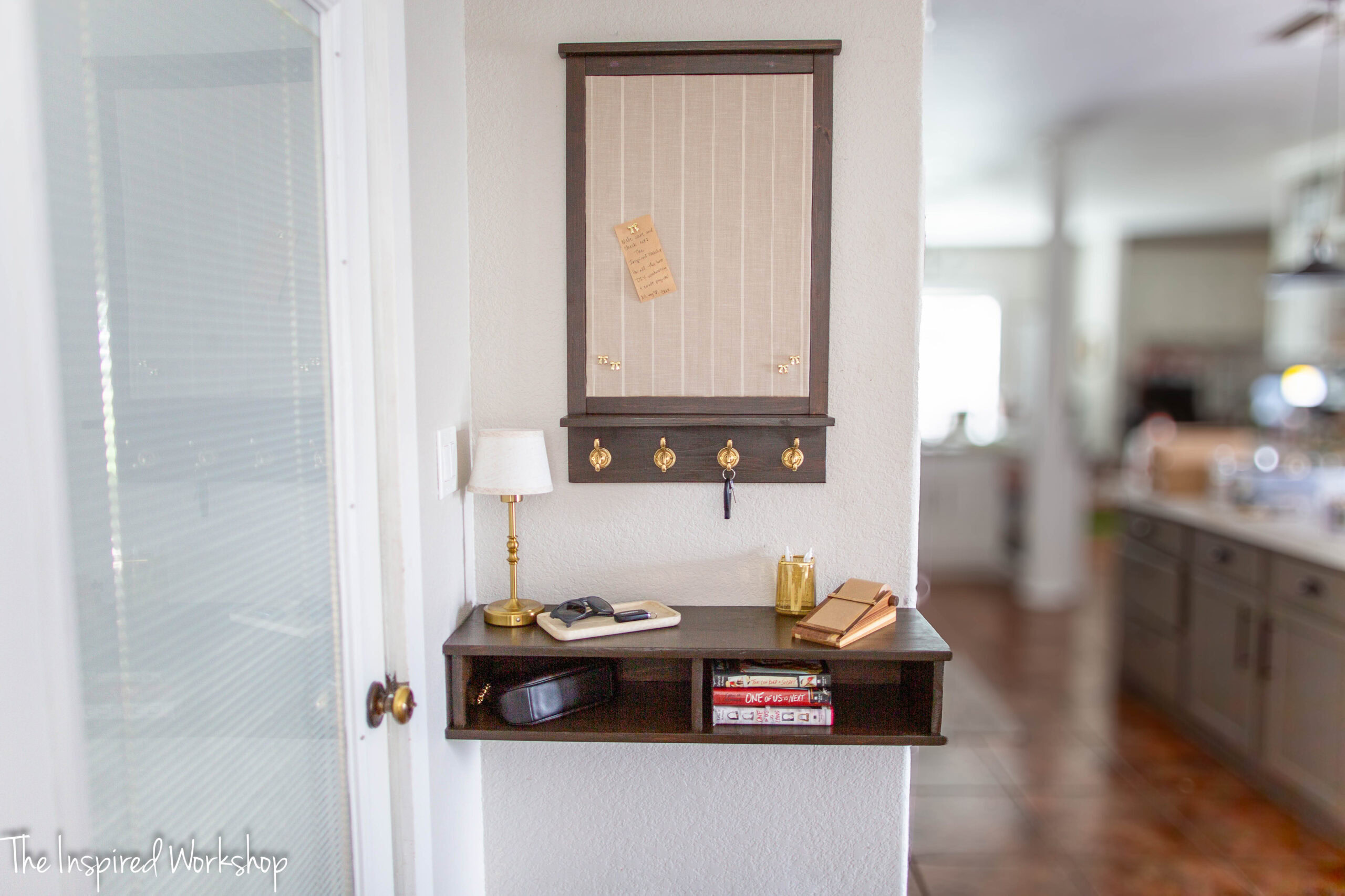 wall mounted shelf with message board above it.
