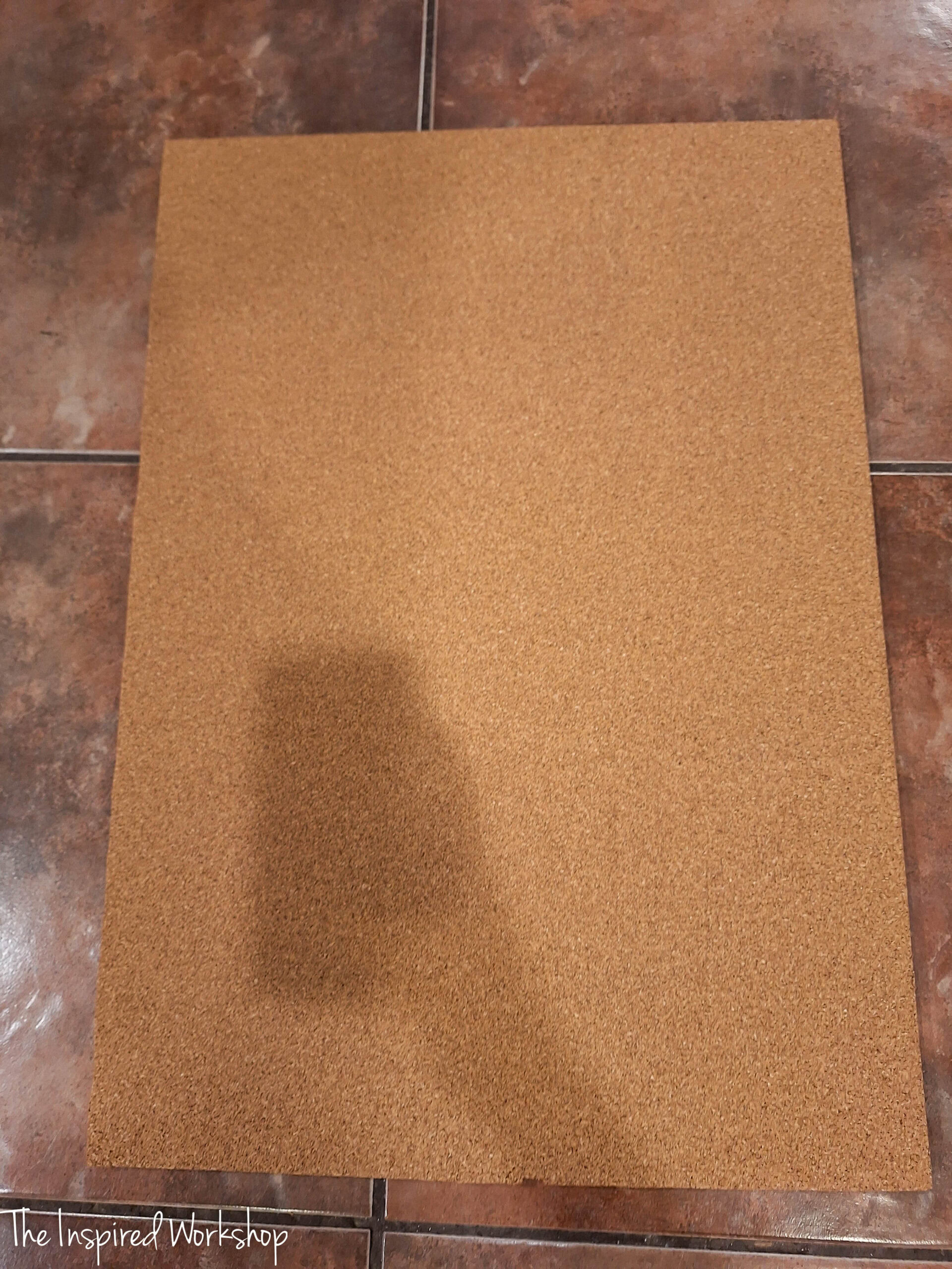 covering the plywood with cork to make the bulletin board for messages