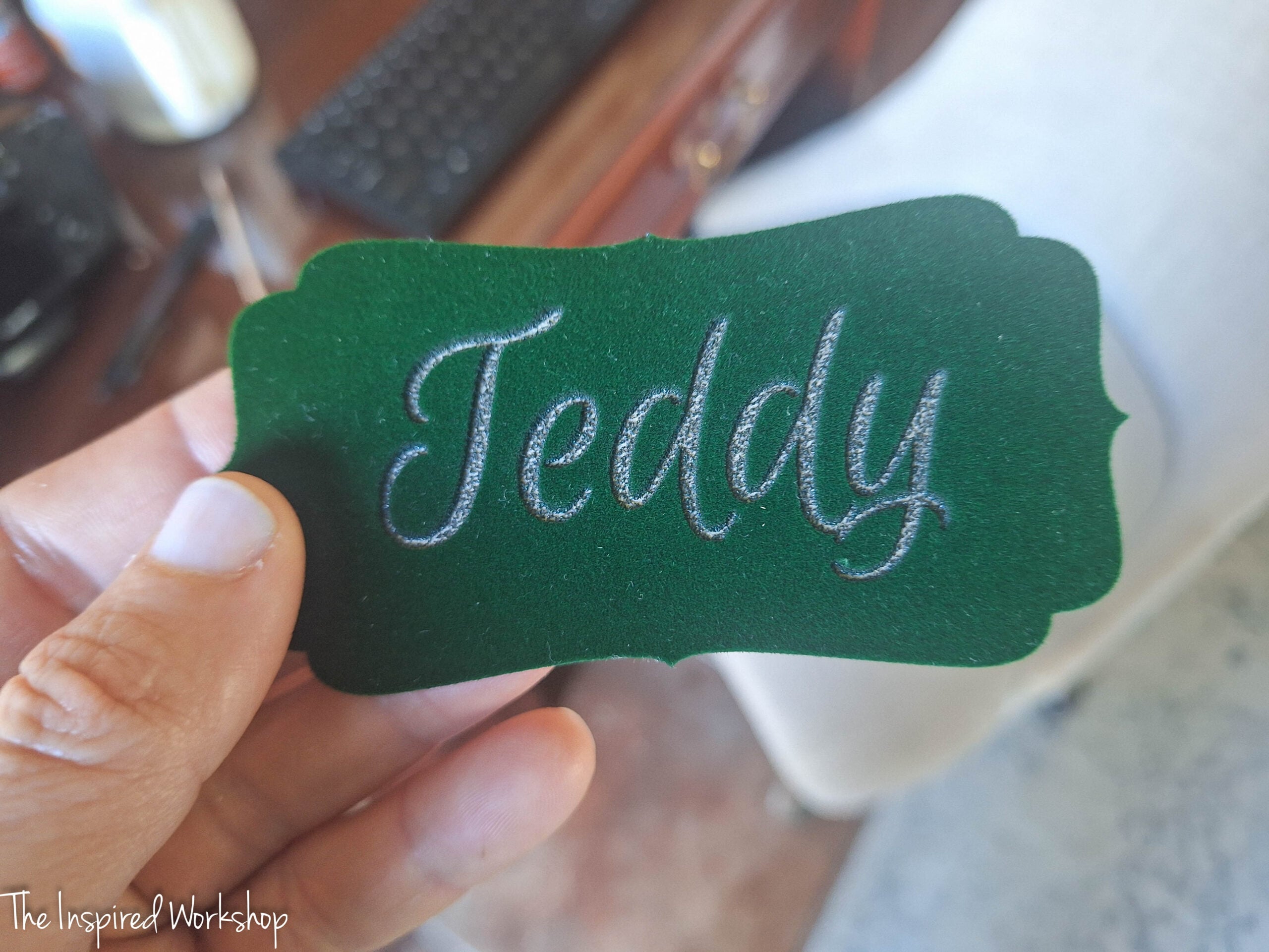 stocking tag in green velvet with a serpentine shape and the name "Teddy" engraved in it.